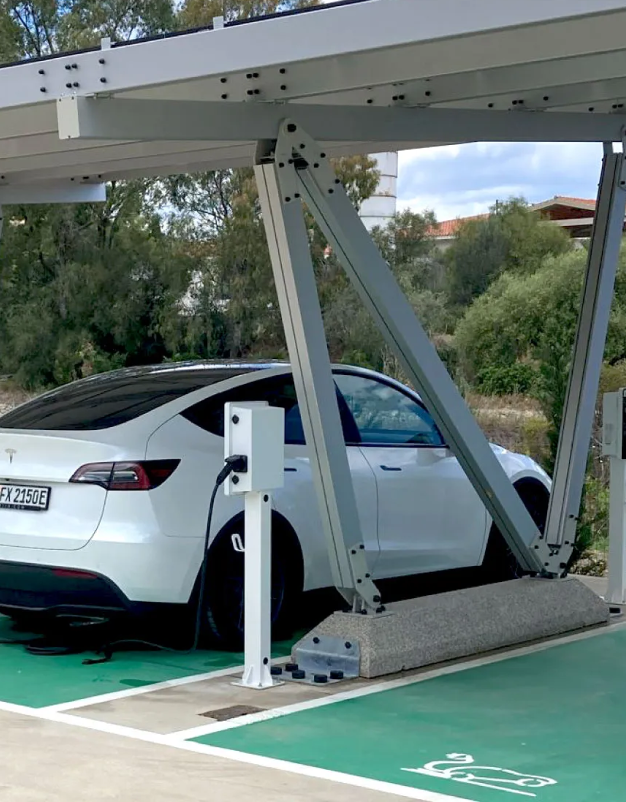 Foto di una macchina elettrica in carica sotto una pergola fotovoltaica