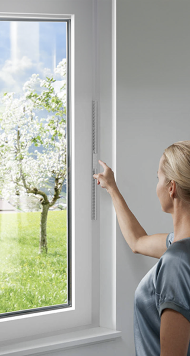 Una donna che apre la finestra. Indica gli infissi di Finestra Moderna