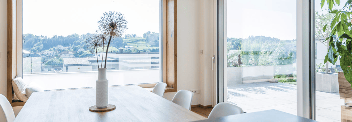 Immagine di una stanza con un tavolo centrale con vetrate a parete