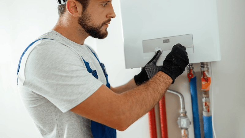 Foto di un collaboratore che fa manutenzione su caldaia